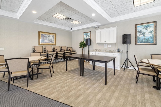 rec room featuring a tray ceiling, crown molding, and light colored carpet