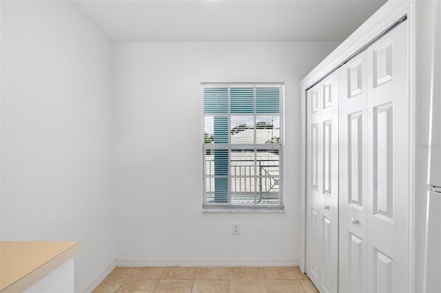 unfurnished bedroom featuring a closet and light tile patterned floors