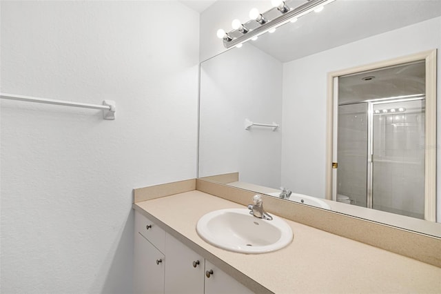 bathroom featuring vanity, toilet, and walk in shower