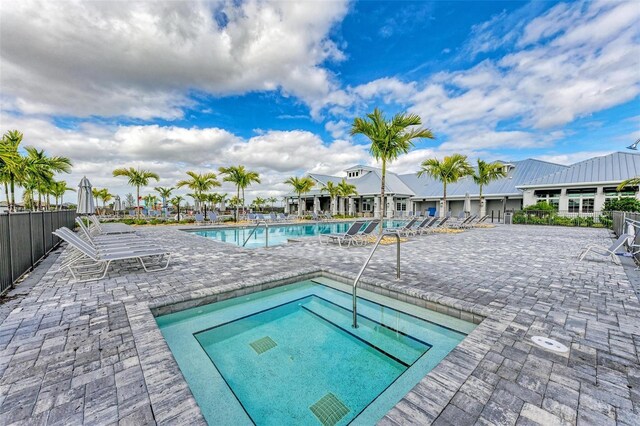 view of pool with a patio and a hot tub