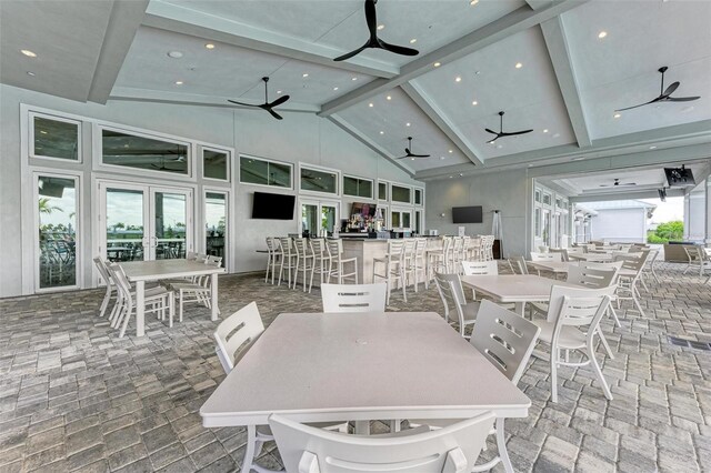 dining room featuring beamed ceiling, high vaulted ceiling, and french doors