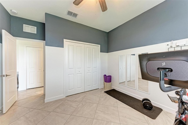 exercise room with light tile patterned floors and ceiling fan