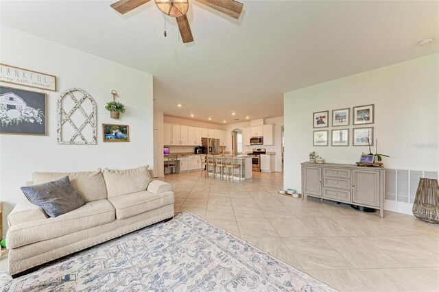 living room with light tile patterned floors and ceiling fan