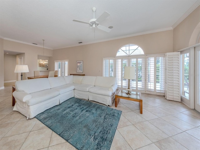 tiled living room featuring ceiling fan with notable chandelier and ornamental molding