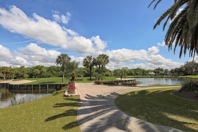 view of home's community with a water view and a yard