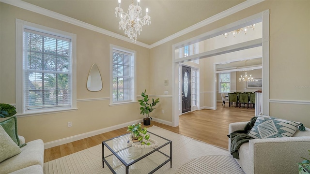 living room featuring a chandelier, crown molding, and light hardwood / wood-style flooring