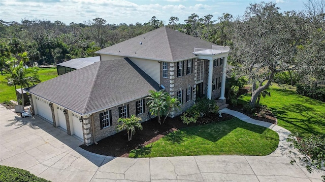 exterior space with a front lawn, a garage, and a balcony