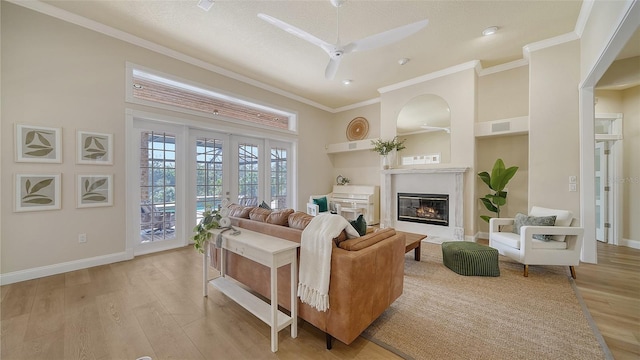 living room with ceiling fan, french doors, crown molding, and light hardwood / wood-style floors