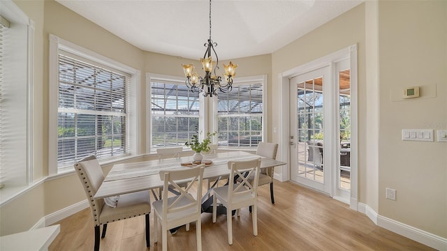 dining space with a notable chandelier, light hardwood / wood-style flooring, and a wealth of natural light