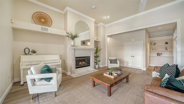 living room with ornamental molding, hardwood / wood-style floors, and built in shelves