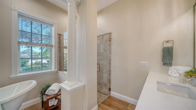 bathroom featuring separate shower and tub, sink, ornate columns, and hardwood / wood-style flooring