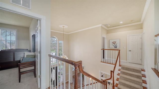 corridor with ornamental molding, light carpet, and an inviting chandelier