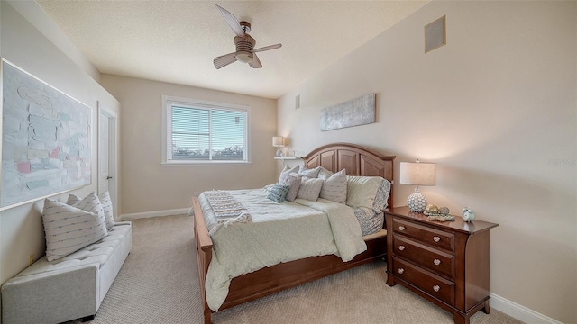 carpeted bedroom with a textured ceiling and ceiling fan