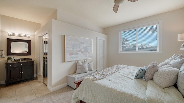 bedroom with sink, connected bathroom, light tile patterned flooring, and ceiling fan