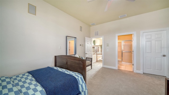 bedroom with ceiling fan, a high ceiling, ensuite bath, and light carpet