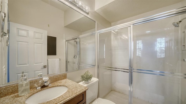 bathroom with toilet, vanity, and walk in shower