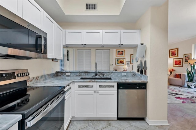 kitchen featuring white cabinets, light stone counters, sink, and appliances with stainless steel finishes