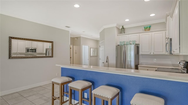 kitchen featuring a breakfast bar area, kitchen peninsula, white cabinets, and stainless steel appliances