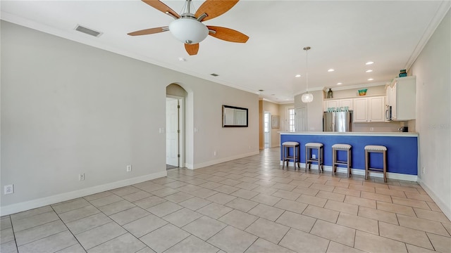 kitchen featuring white cabinetry, ornamental molding, decorative light fixtures, and appliances with stainless steel finishes