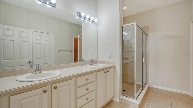 bathroom with tile patterned floors, vanity, and a shower with door