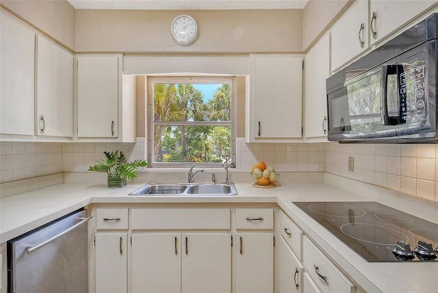 kitchen with sink, backsplash, black appliances, and white cabinets