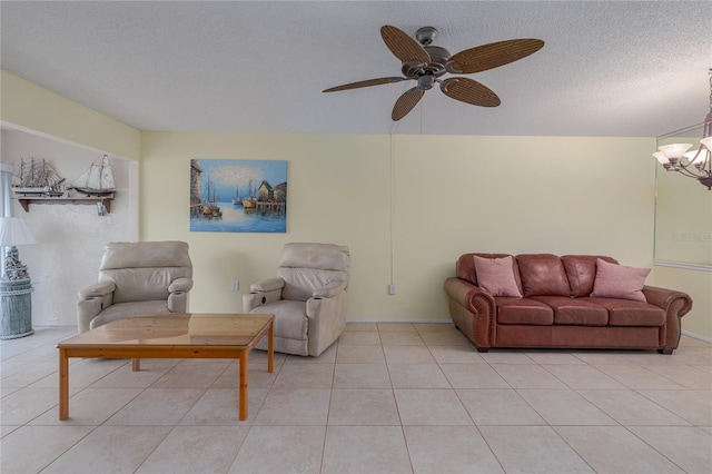 living room with light tile patterned floors, ceiling fan with notable chandelier, and a textured ceiling