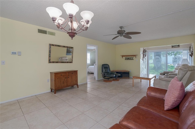 tiled living room with ceiling fan with notable chandelier and a textured ceiling