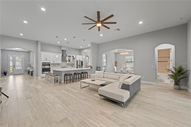 living room with french doors and ceiling fan with notable chandelier