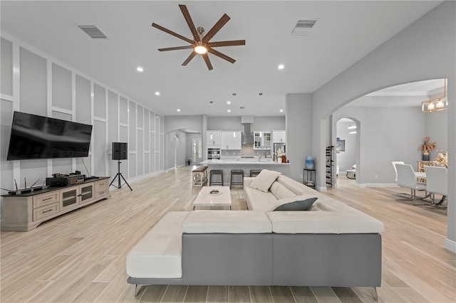 living room featuring ceiling fan and light hardwood / wood-style floors