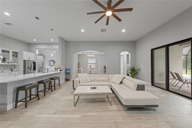 living room with ceiling fan, light tile flooring, and sink