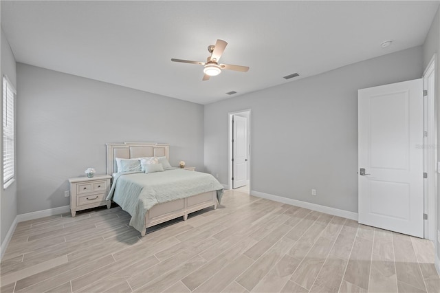 bedroom with ceiling fan, multiple windows, and light wood-type flooring