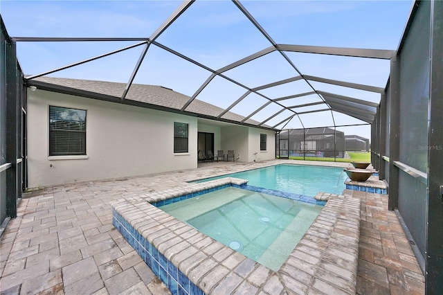 view of pool featuring a lanai, an in ground hot tub, and a patio area