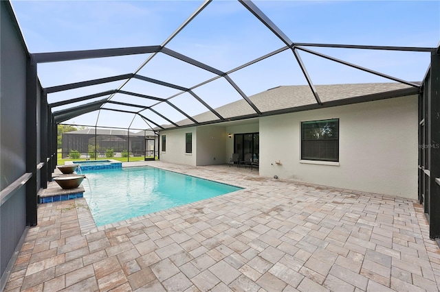 view of pool featuring an in ground hot tub, a patio, and a lanai