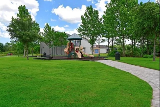 view of home's community featuring a playground and a yard