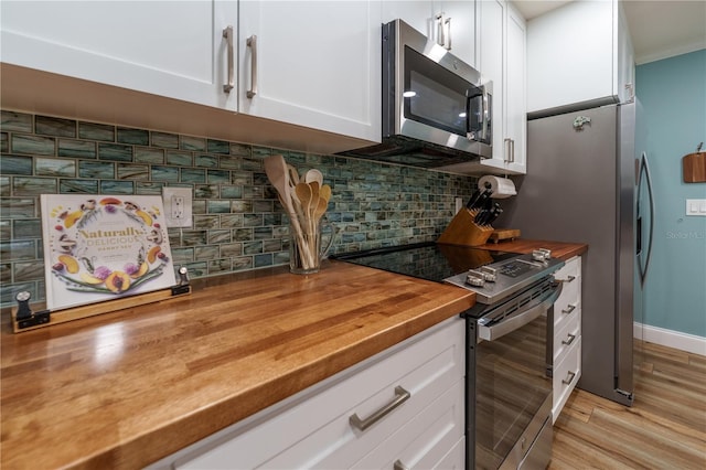 kitchen featuring white cabinetry, tasteful backsplash, wooden counters, appliances with stainless steel finishes, and light wood-type flooring