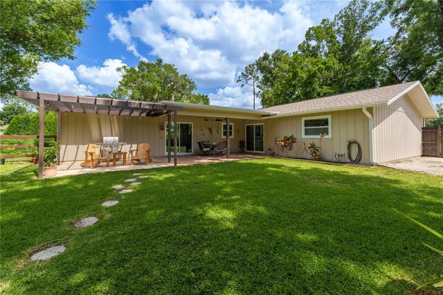 rear view of house featuring a lawn, a pergola, and a patio