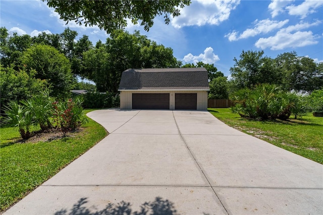 view of front of property featuring an outdoor structure and a front yard