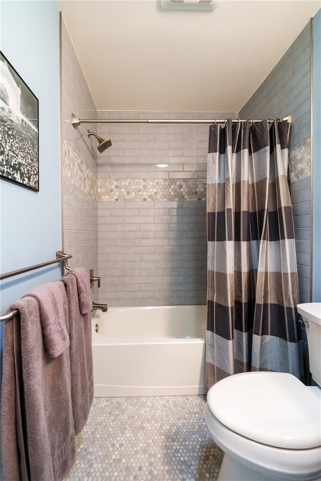 bathroom featuring tile patterned floors, shower / bath combo, and toilet