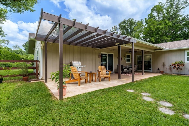 rear view of house with ceiling fan, a patio area, a pergola, and a yard