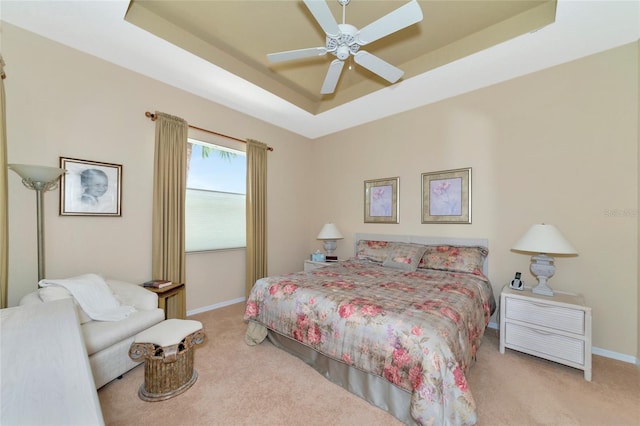 bedroom featuring ceiling fan, a raised ceiling, and carpet floors