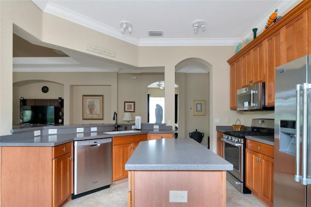 kitchen featuring ornamental molding, a kitchen island, appliances with stainless steel finishes, sink, and light tile floors