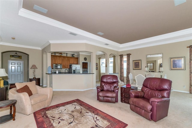 carpeted living room featuring a raised ceiling, sink, and crown molding