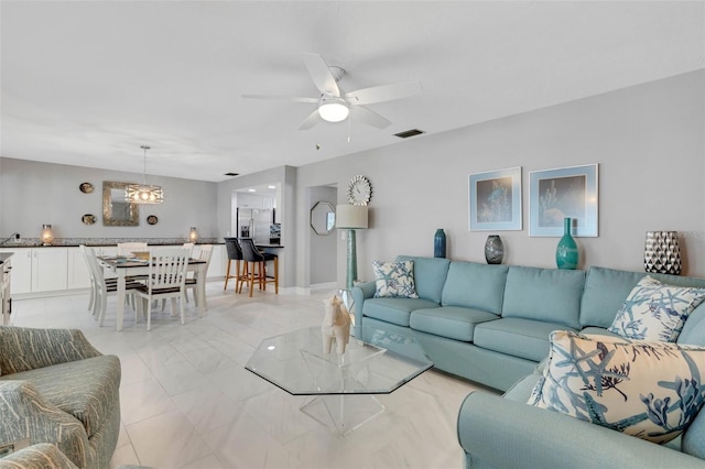 living room with ceiling fan with notable chandelier