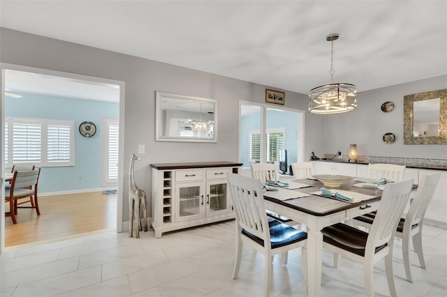 tiled dining area with a healthy amount of sunlight and a notable chandelier