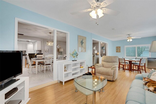 living room with ceiling fan and light hardwood / wood-style flooring