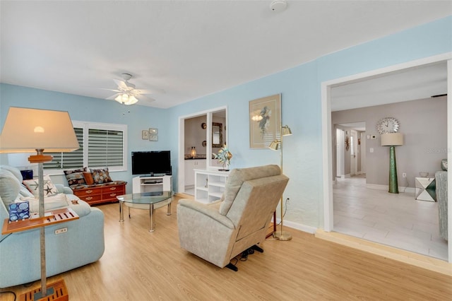 living room featuring hardwood / wood-style floors and ceiling fan