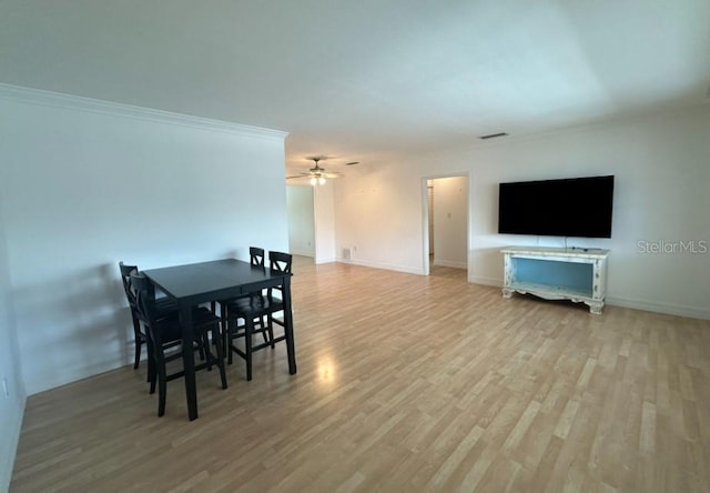 dining area featuring ceiling fan, crown molding, and light hardwood / wood-style flooring