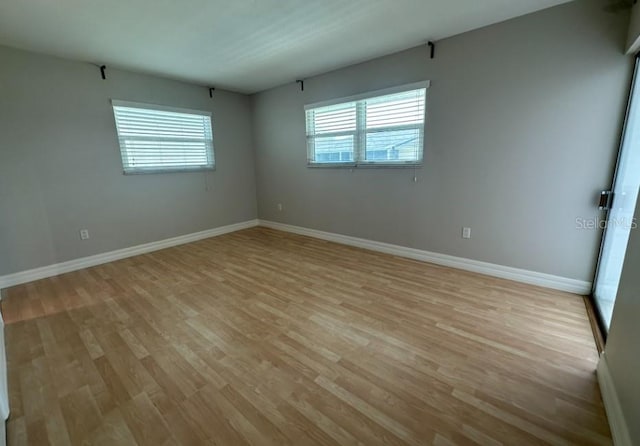 empty room featuring light wood-type flooring and a wealth of natural light