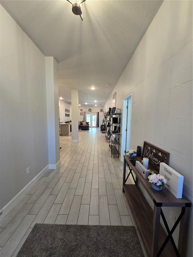 hall featuring a textured ceiling