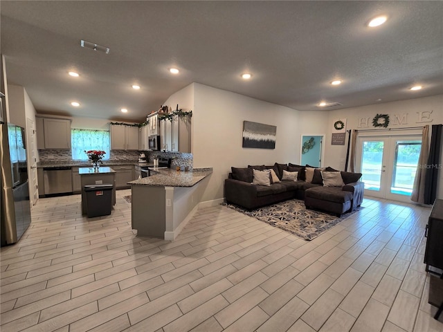 kitchen featuring appliances with stainless steel finishes, gray cabinetry, kitchen peninsula, decorative backsplash, and french doors